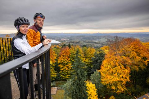 Zwei Gravelbiker stehen auf der Aussichtsplattform des Ungerturms auf dem Ungerberg und genießen die herbstliche Aussicht über die Sächsische Schweiz. Der RockHead führt direkt zum Ungerberg.