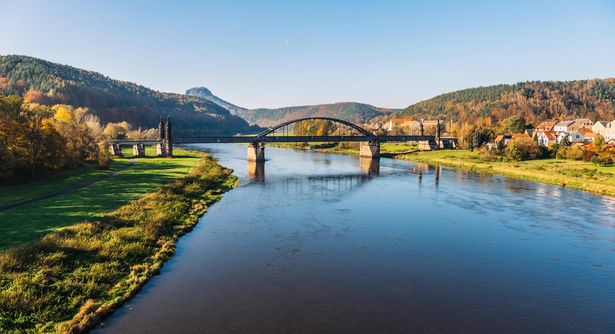 Elbe fließt entlang Bad Schandau, im Mittelpunkt die Brücke, bei klarem blauen Himmel